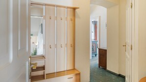 Ein Flur mit einem Holzschrank, einem Spiegel und einer Tür zu einem anderen Raum.