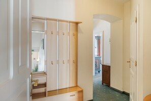 Ein Flur mit einem Holzschrank, einem Spiegel und einer Tür zu einem anderen Raum.