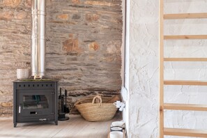 Un muro de piedra, una escalera de madera, una chimenea con sus conductos y una cesta tejida.