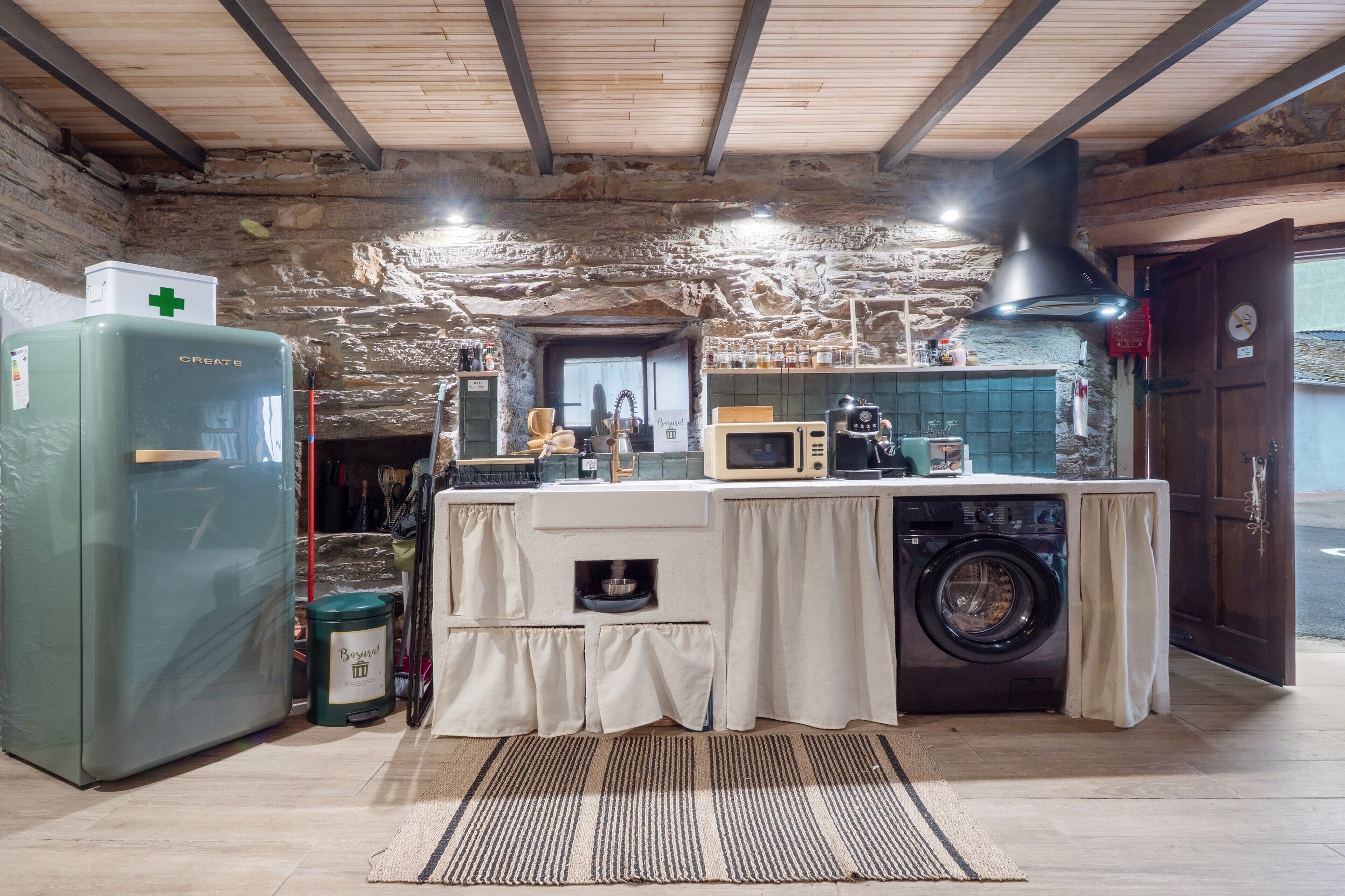 Une cuisine rustique équipée d’un lave-linge, d’un four à micro-ondes et d’un réfrigérateur.