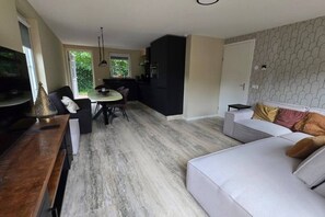 Un espacio de estar moderno con comedor, cocina y zona de asientos.