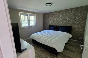 Una camera da letto con un letto, una finestra e una televisione su un mobile.