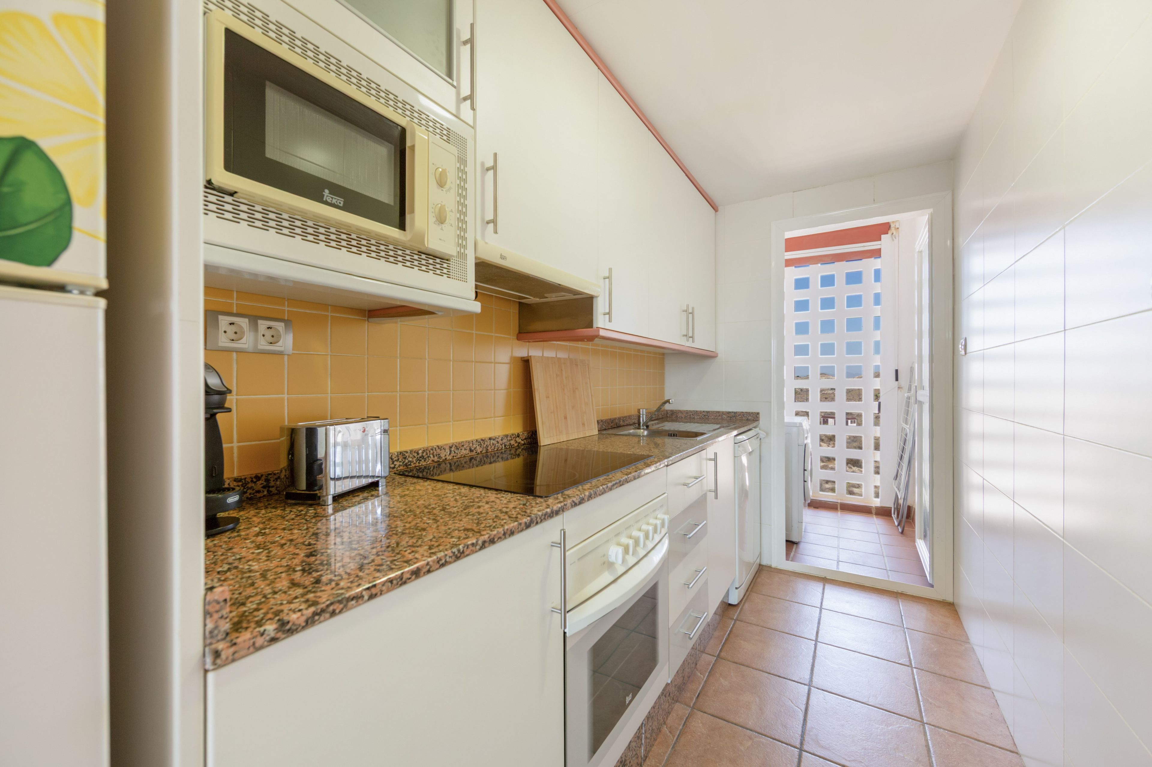 A kitchen with a microwave, toaster, and sink.