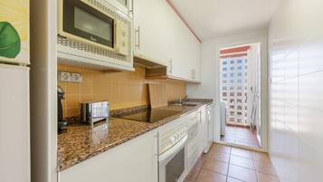 A kitchen with a microwave, toaster, and sink.
