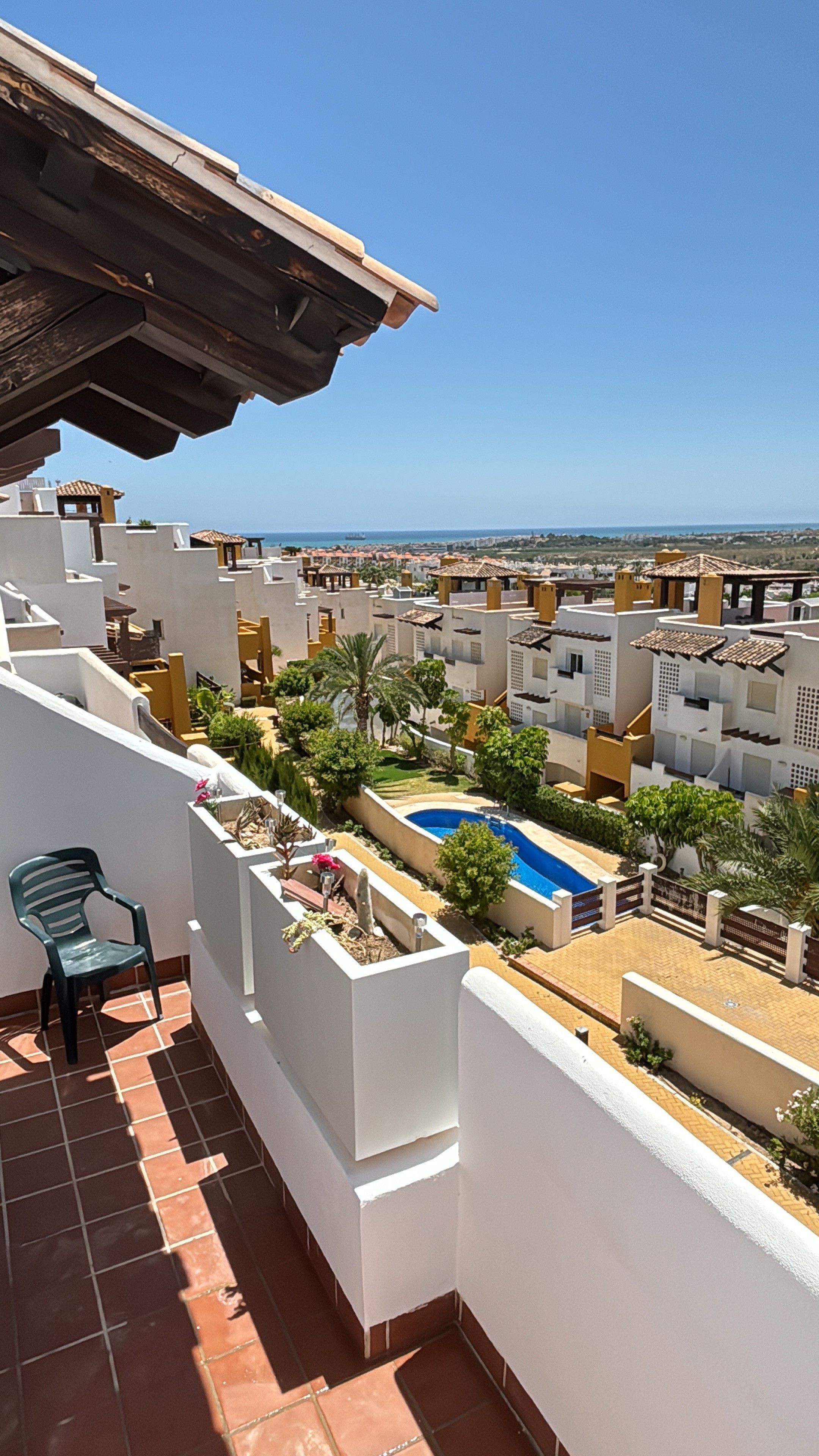 Un quartier résidentiel doté d’une piscine, de murs blancs et offrant une vue dégagée sur la mer.
