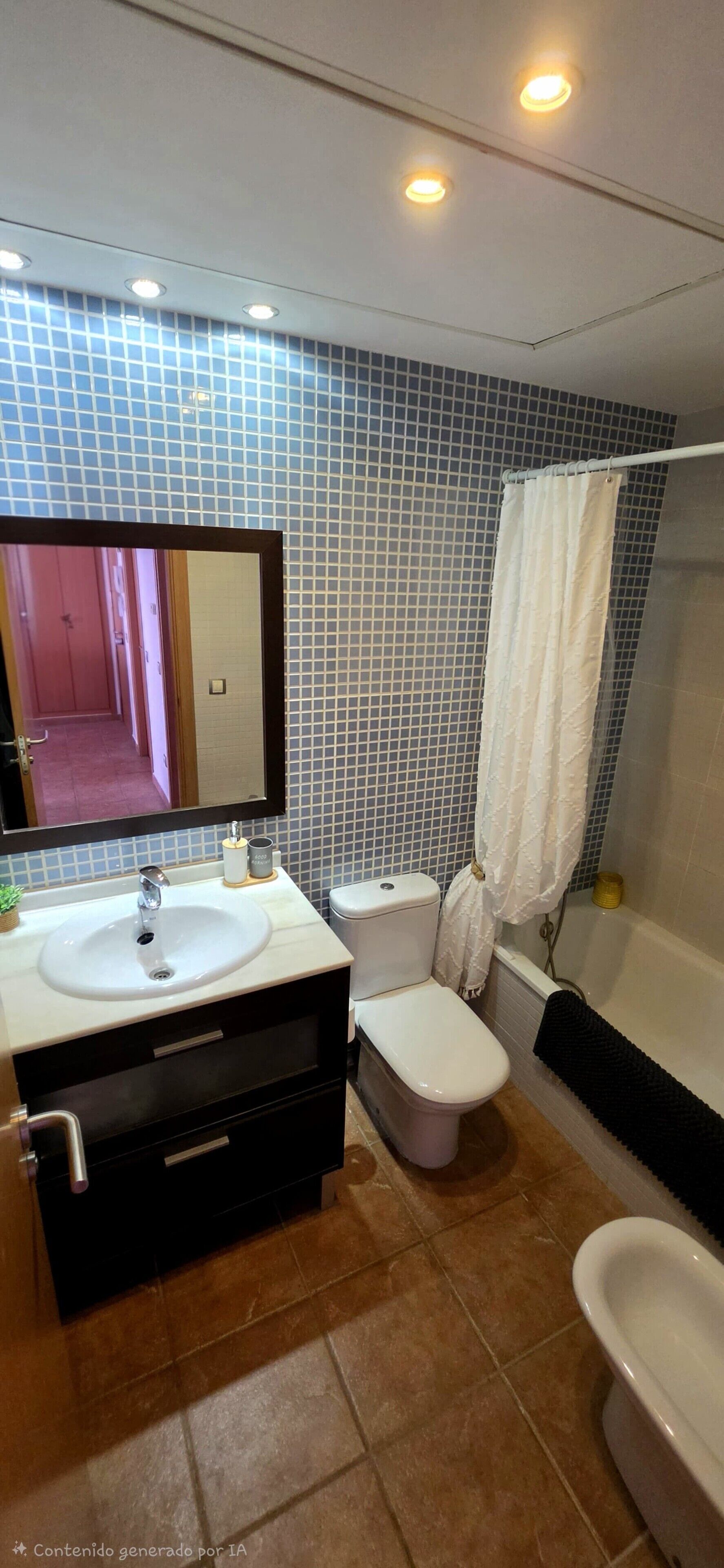 Un baño con lavamanos, inodoro y bañera.