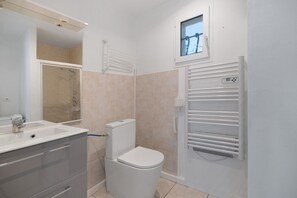 A modern bathroom with a toilet, sink, and a towel rack.