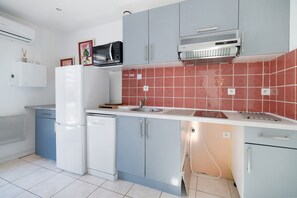 A compact kitchen with a built-in microwave, a dishwasher, and a sink.