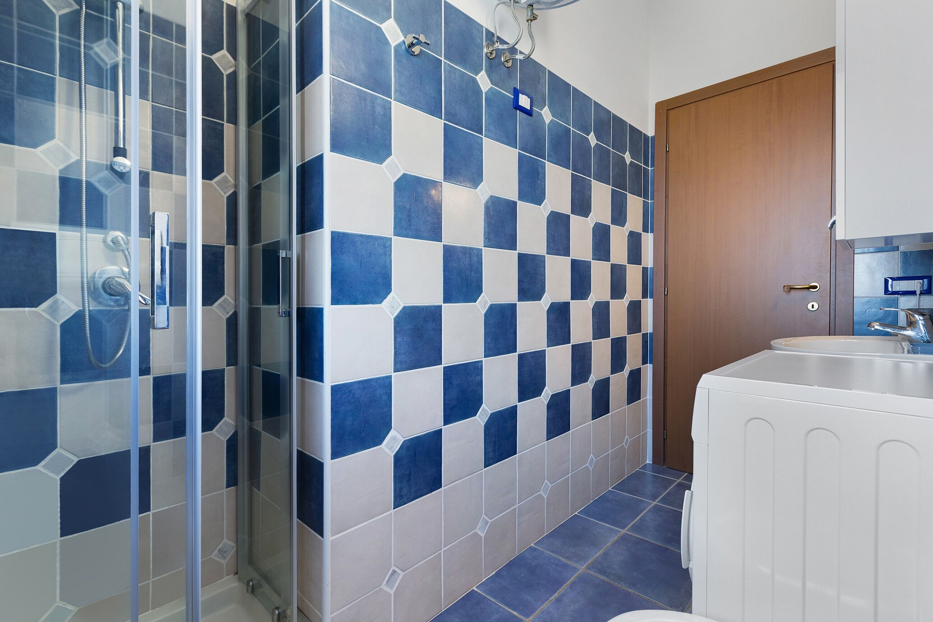 Une salle de bain avec douche, toilettes et lavabo.
