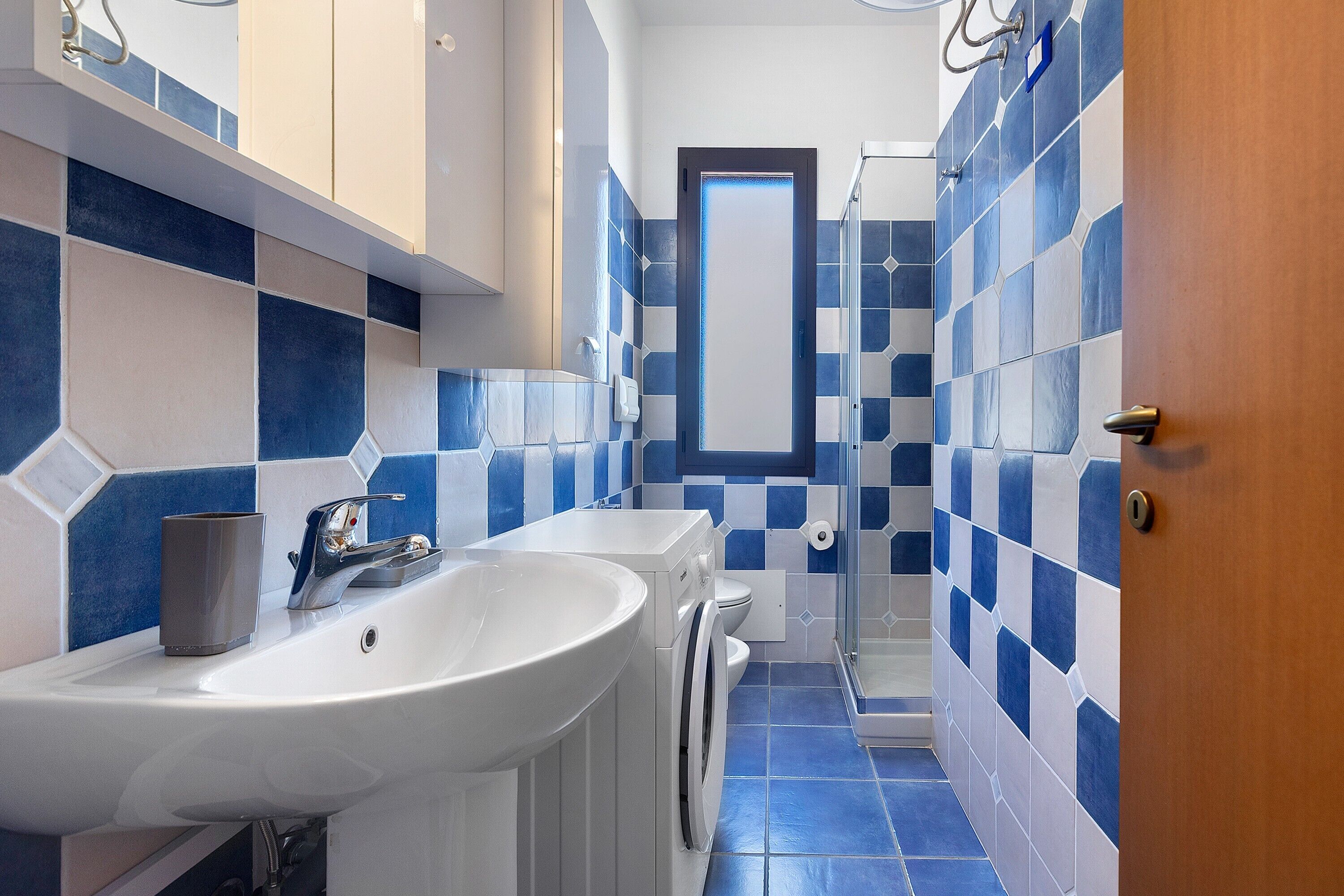 Ein modernes Badezimmer mit Waschbecken, Spiegel und Dusche.