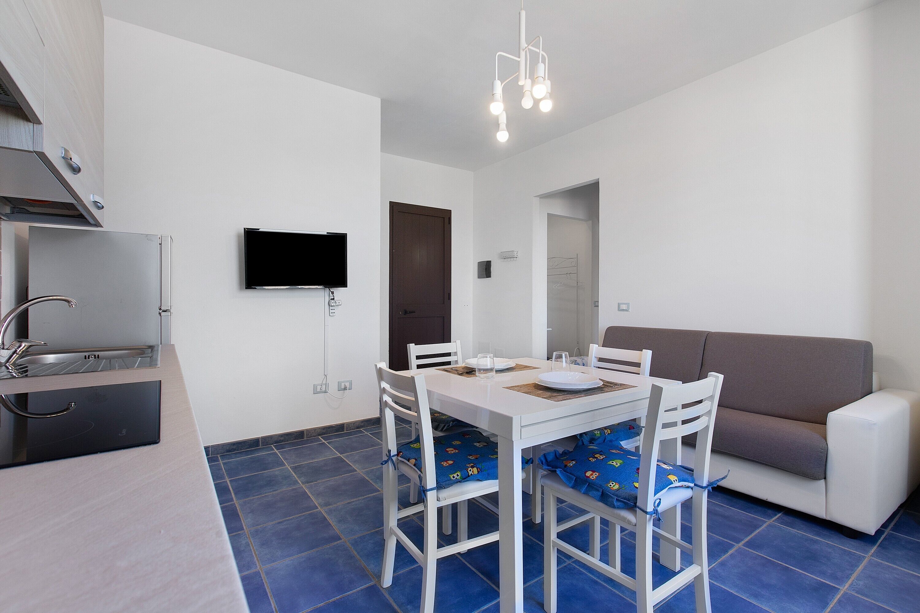 Een kleine woonruimte met een kitchenette, een eethoek en zithoek.