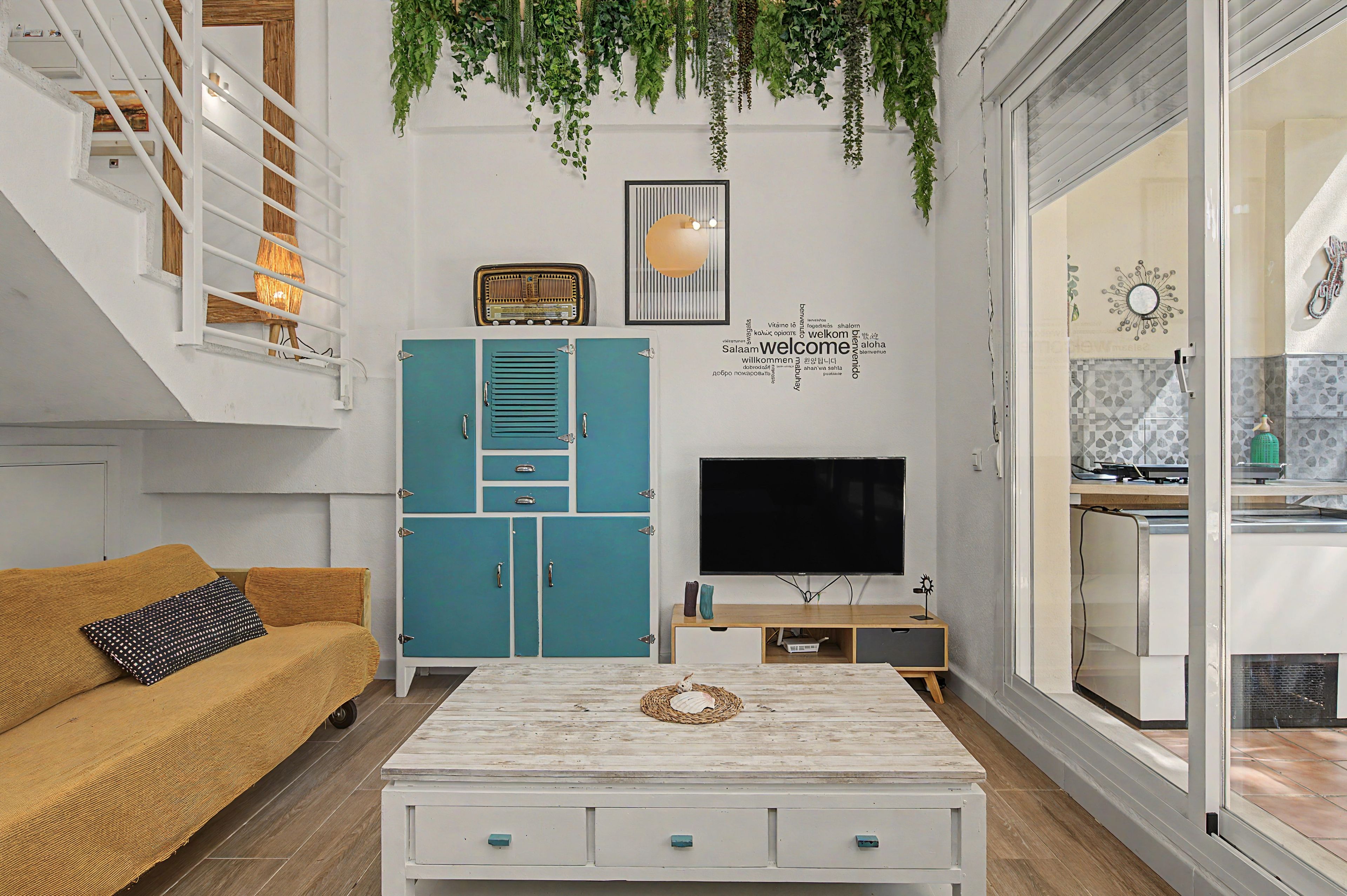 Una sala de estar con un sofá, una mesa de centro, un televisor y un mueble.