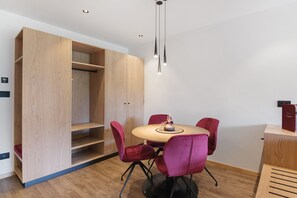 Ein modernes Zimmer mit einem Holzesstisch, roten Stühlen und einem Einbauschrank.
