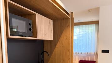 Eine moderne Küche mit integrierten Geräten, Holzschränken und einer schwarzen Arbeitsplatte.