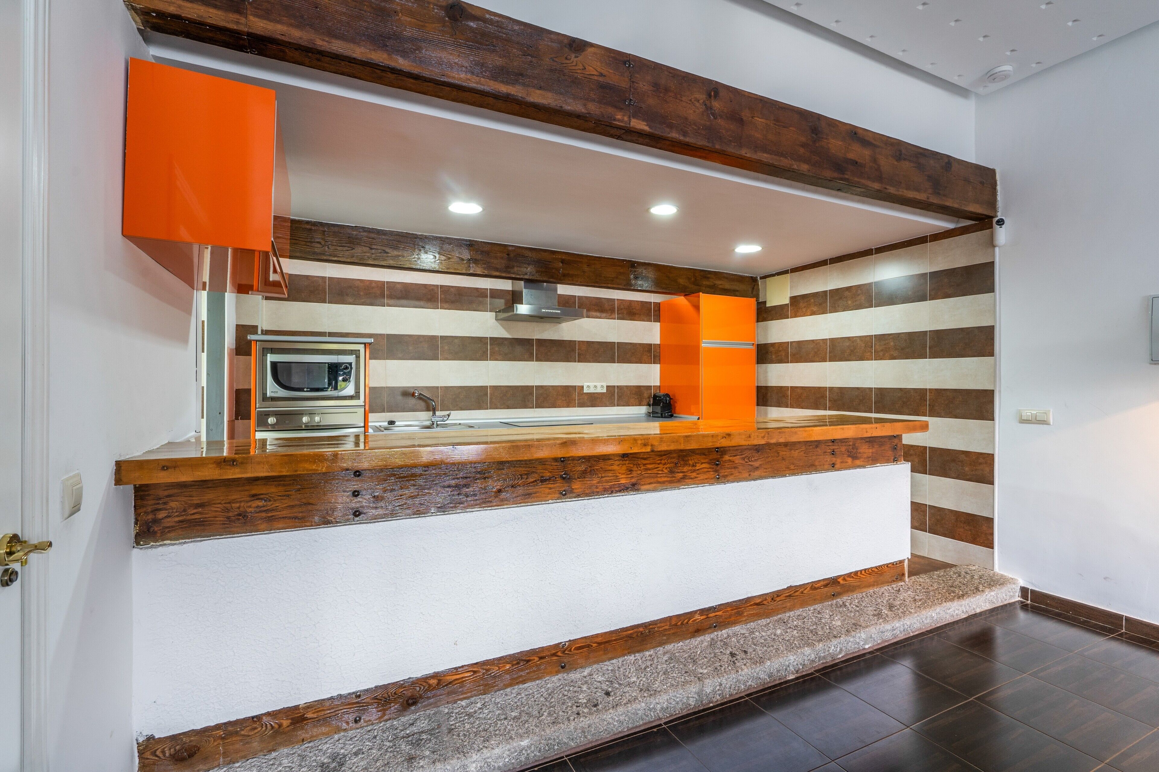 A kitchen with a wooden countertop, a built-in oven, and a modern faucet.