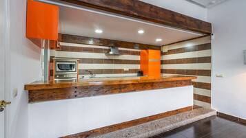 A kitchen with a wooden countertop, a built-in oven, and a modern faucet.