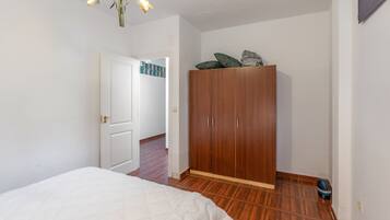 Un dormitorio con una cama, un armario y una puerta que da a otra habitación.