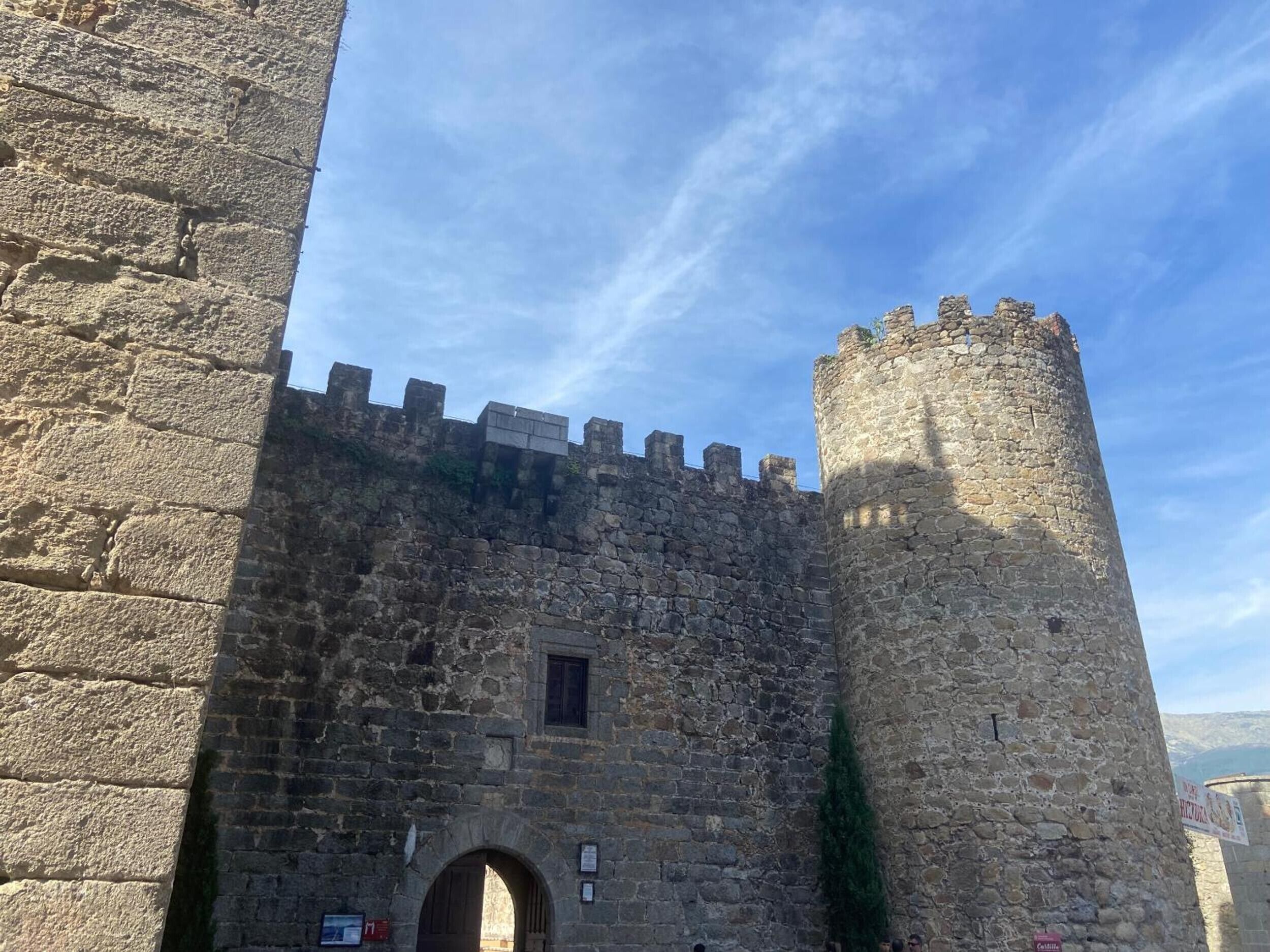 A stone castle with a large arched entrance and a tall tower.