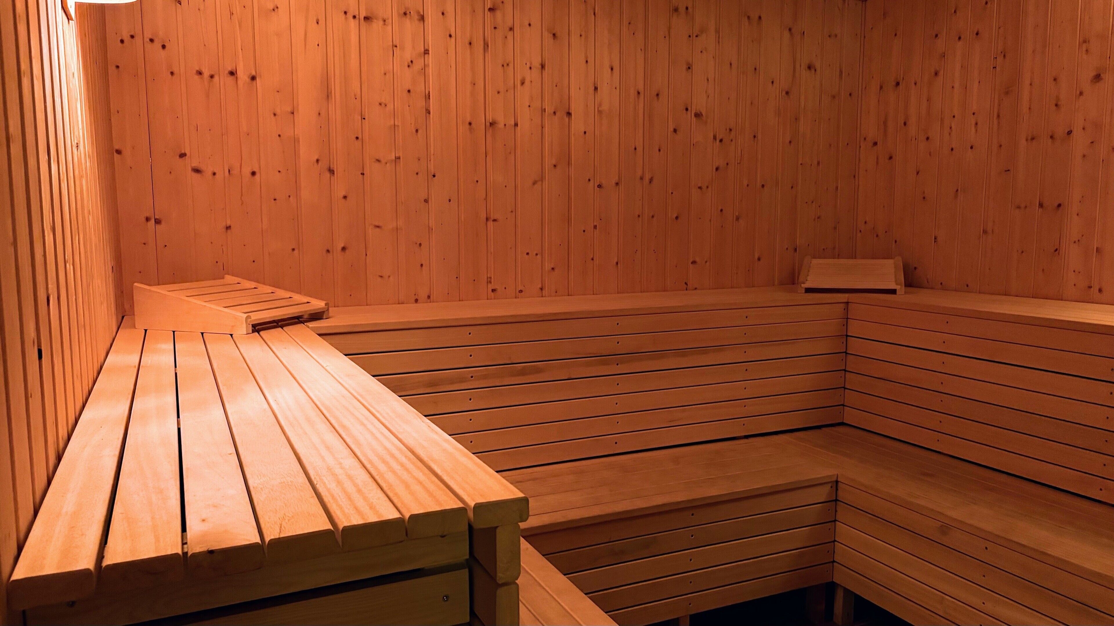 A sauna with wooden benches and a bench area.
