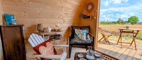 A cozy interior with a rocking chair, a leather sofa, and a dining table with dishes.