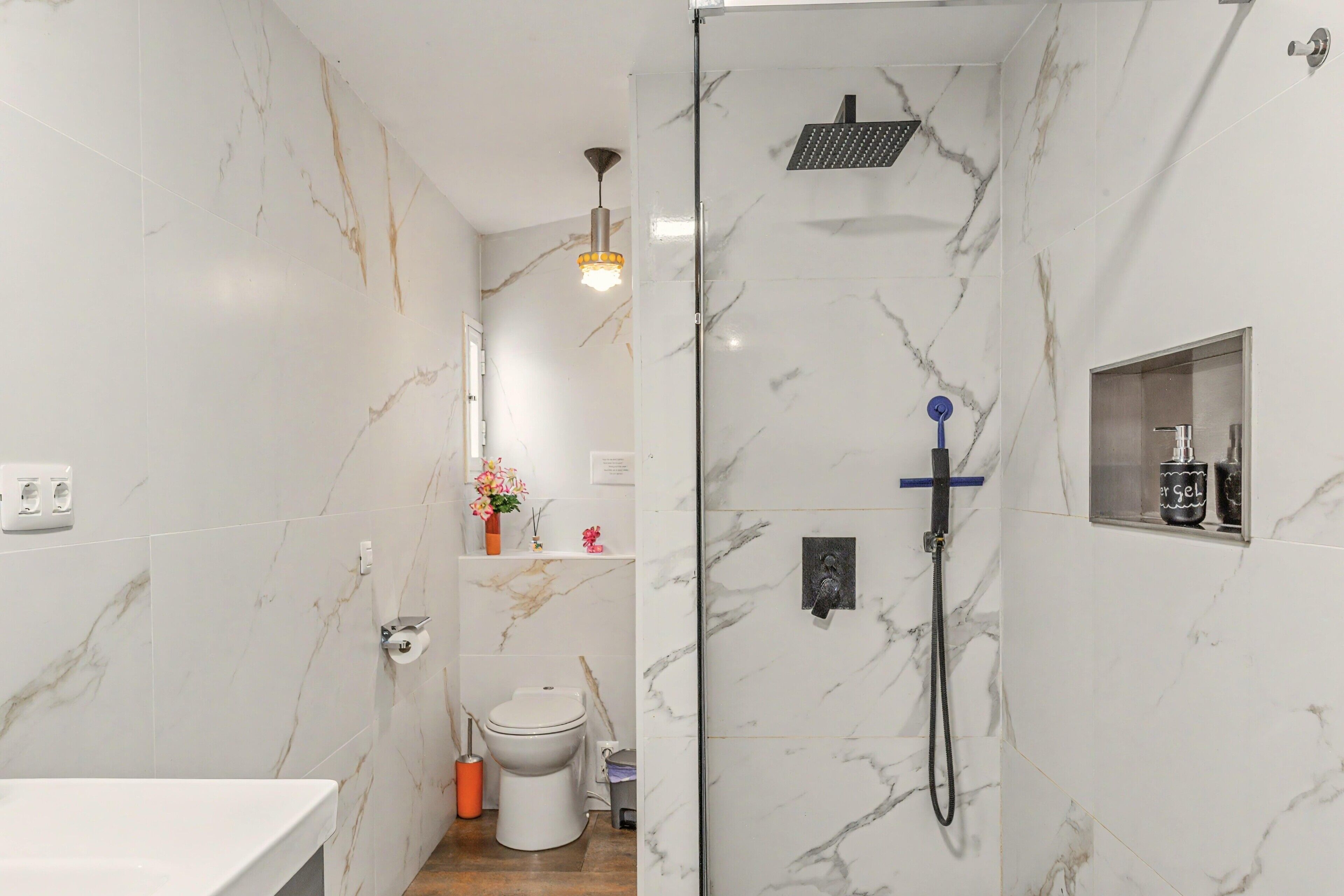 A bathroom with a shower, toilet, and sink.