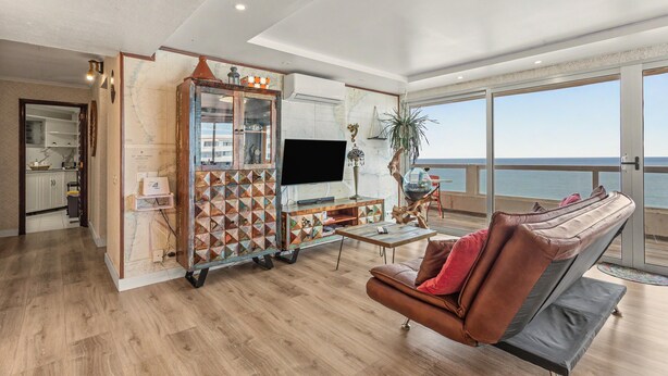 Un salon moderne avec une grande télévision, un meuble en bois et un canapé en cuir.