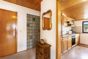 A kitchen with wooden cabinets, a stove, and a window. - Apartment 'Fewo Wrede Am Sauerland-Radring 2' with Mountain View, Balcony and Wi-Fi (Eslohe)