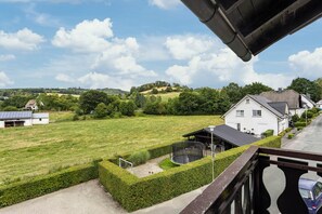 A residential area with houses, a grassy field, and a clear sky. - Apartment 'Fewo Wrede Am Sauerland-Radring 2' with Mountain View, Balcony and Wi-Fi (Eslohe)