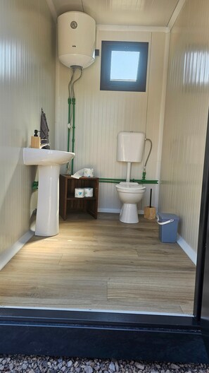 A compact bathroom with a toilet, sink, and window.