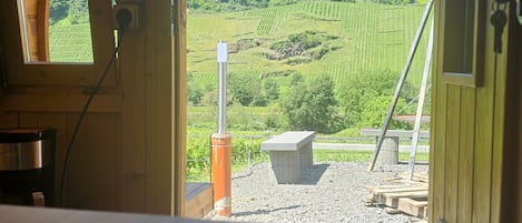 Une chambre avec un lit, une fenêtre et une vue sur un paysage verdoyant avec une colline.