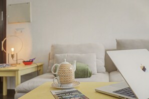 Un ordinateur portable est posé sur une table, à côté d’un livre et d’une théière.