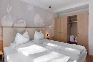 Une chambre moderne avec un grand lit, une armoire en bois et une table de chevet.