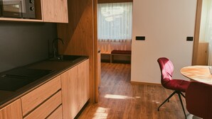 Eine moderne Küche mit Holzschränken, einer eingebauten Mikrowelle und einer schwarzen Arbeitsplatte.