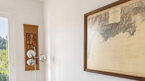 Un salon moderne avec un canapé foncé, une lampe sur pied et une carte accrochée au mur.