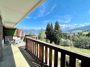 A balcony with a wooden railing overlooking a mountainous landscape. - Reflection of Mont Blanc (Combloux)