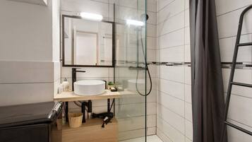 Une salle de bain moderne avec une douche à parois de verre, un meuble-lavabo en bois et un miroir au-dessus du lavabo.