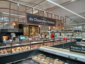 A bakery section in a supermarket with a variety of baked goods on display.