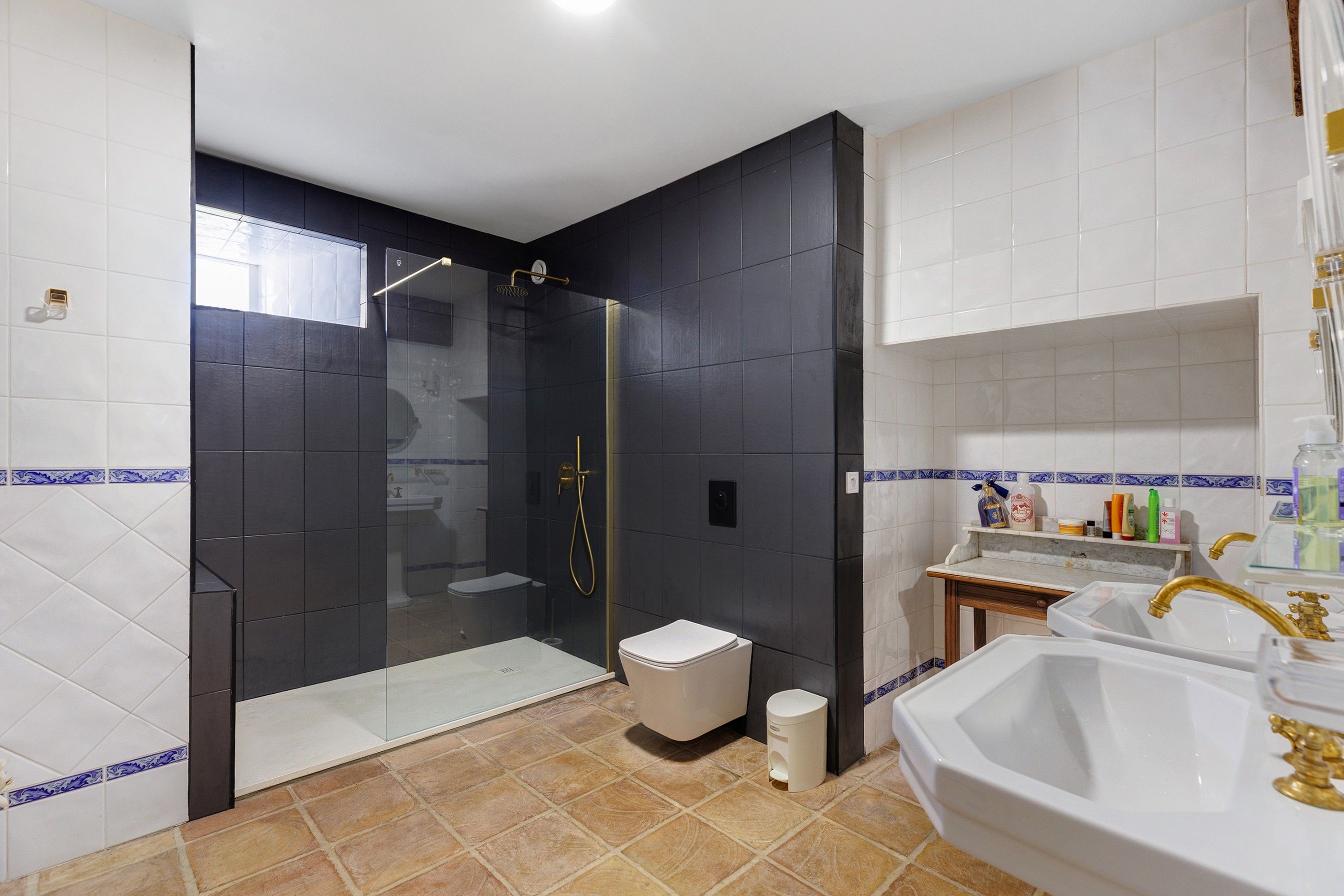 Une salle de bain moderne avec une douche à parois de verre, des toilettes blanches et un meuble-lavabo avec un évier et un miroir.