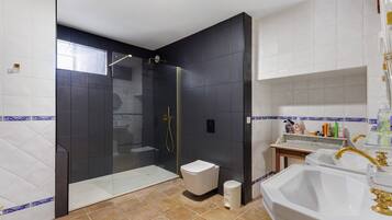 Une salle de bain moderne avec une douche à parois de verre, des toilettes blanches et un meuble-lavabo avec un évier et un miroir.