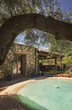 A stone building with a pool, surrounded by olive trees and potted plants. - The Olive Grove – Luxury Country Resort with Panoramic Views and Private SPA in Sardinia (Quartu Sant'Elena)