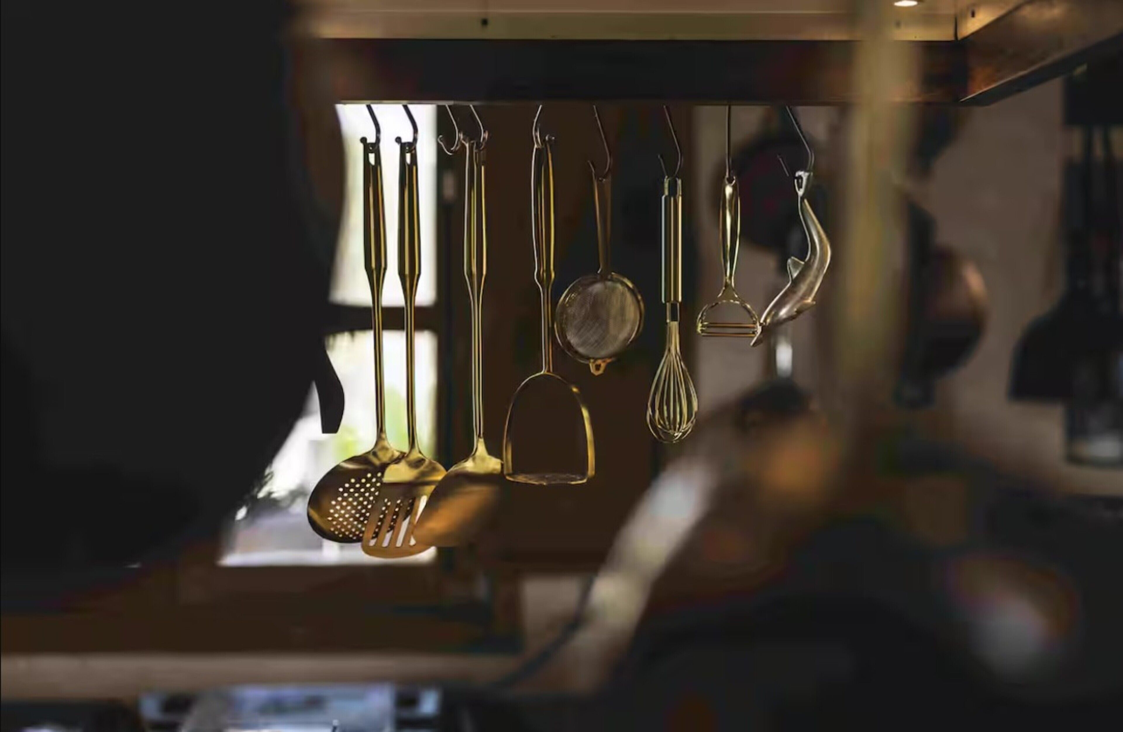 Une cuisine avec différents ustensiles accrochés au mur.