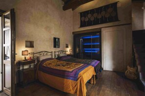 A bedroom with two beds, a guitar, and a blue-lit window. - The Olive Grove – Luxury Country Resort with Panoramic Views and Private SPA in Sardinia (Quartu Sant'Elena)