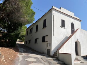Un bâtiment blanc doté de nombreuses fenêtres et d’un escalier menant à l’entrée.