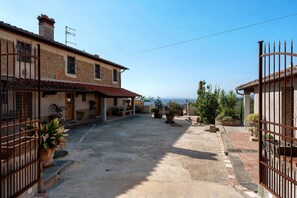 Un patio con edificios de piedra, una reja y plantas en macetas.