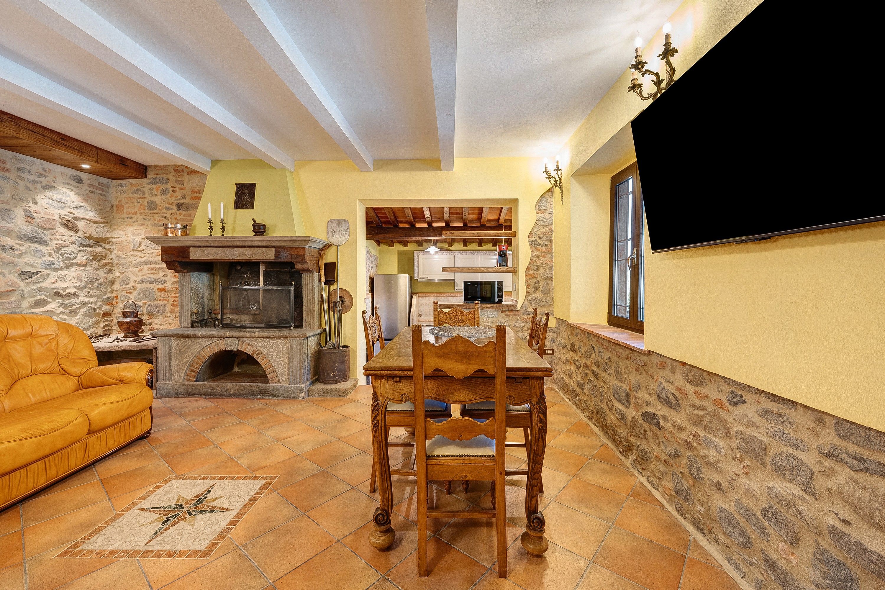 A cozy living room with a fireplace, a dining table, and a sofa.