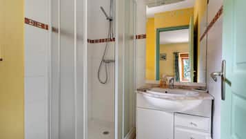 A bathroom with a shower, a sink, and a mirror.