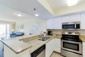 A modern kitchen with granite countertops, stainless steel appliances, and white cabinetry. - Carolinian Beach Resort 1830 (Myrtle Beach)