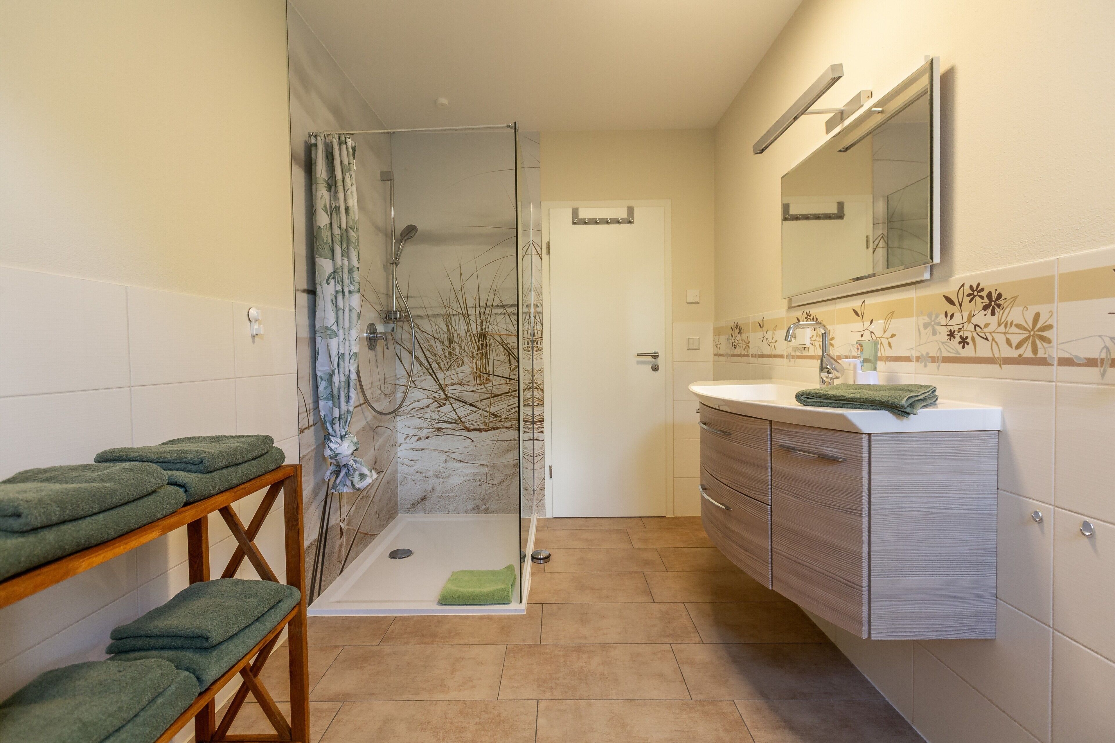 Ein Badezimmer mit Dusche, Waschbecken und Spiegel.