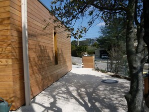 A wooden building with a paved pathway leading to a gated entrance. - Cottage "Bois" with Private Pool, Wi-Fi, and Air Conditioning (Saint-Romain-en-Viennois)
