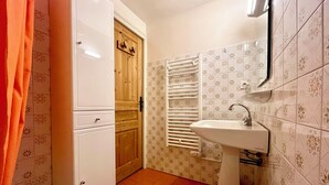 A bathroom with a white sink, a wooden door, and patterned tiles. - Ski-in/ski-out apartment with balcony in Combloux (Combloux)
